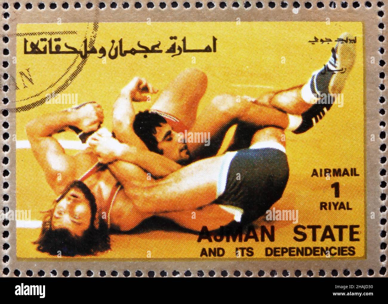 AJMAN - CIRCA 1973: a stamp printed in the Ajman shows Wrestling, Olympic sports, circa 1973 Stock Photo