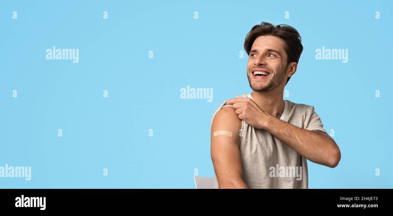 Man Showing Arm With Sticking Plaster After Vaccine Injection And Looking Away Stock Photo