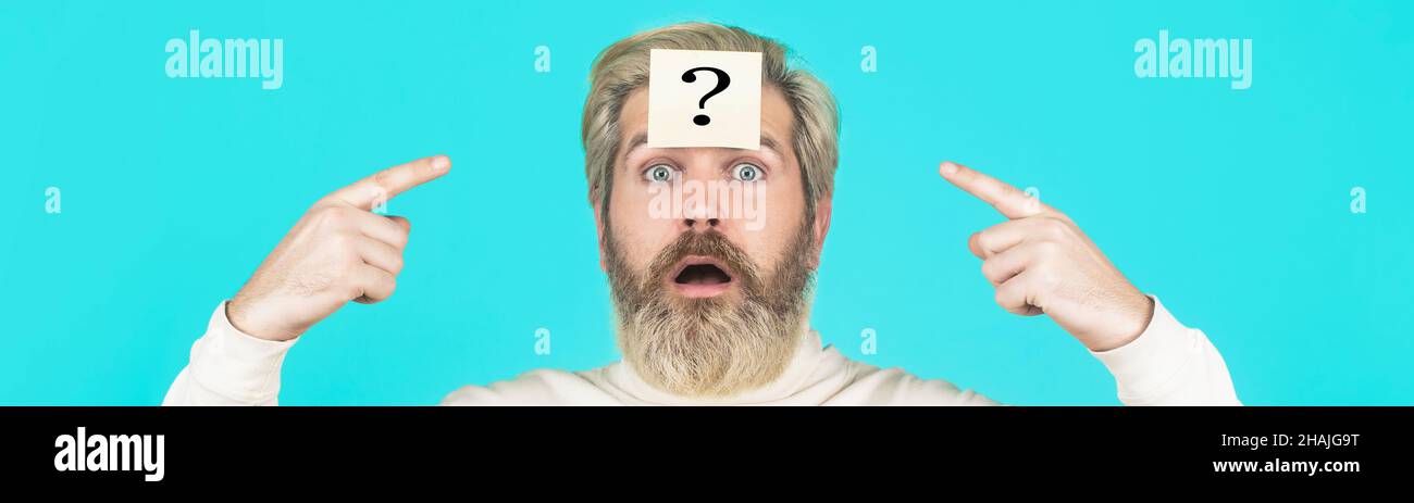 Beard man question mark in head, solution problems. Thinking man with question mark on blue background. Man with question mark on forehead looking up Stock Photo