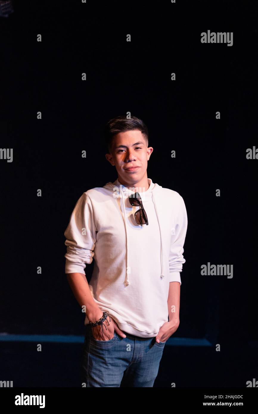 Young Hispanic male posing in front of a black background Stock Photo