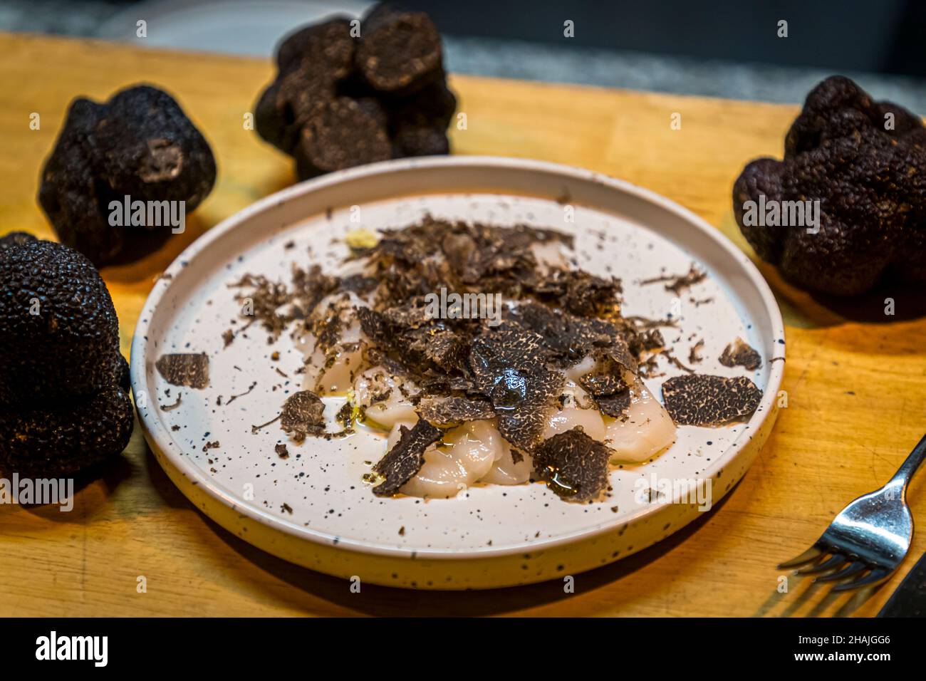 Fresh scallops seasoned with sea salt, black pepper and olive oil and freshly shaved black truffle.  Reduced to these few ingredients, the flavor of the black truffle comes out very well. Aups, France Stock Photo