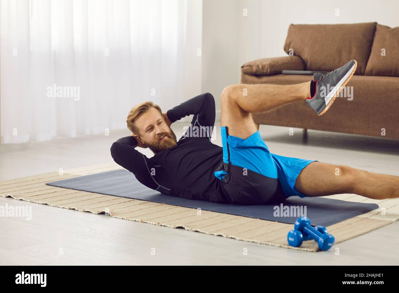 Handsome young man doing bicycle crunches exercise during fitness workout at home Stock Photo Alamy