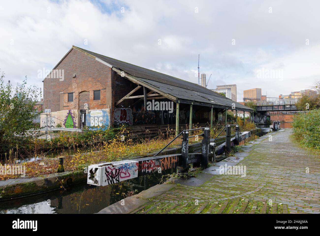 Birmingham West Midlands, UK, December 1st 2021: An abandoned warehouse stands by disused lock gates on the Grand Union Canal near Digbeth Junction. Stock Photo