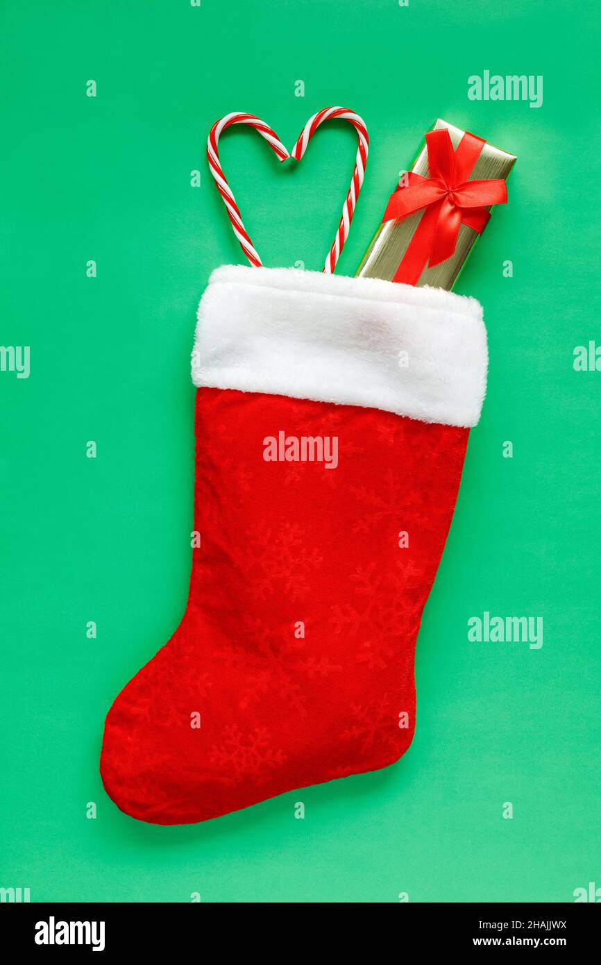 Christmas stocking with small gift box and candy canes in heart shape ...