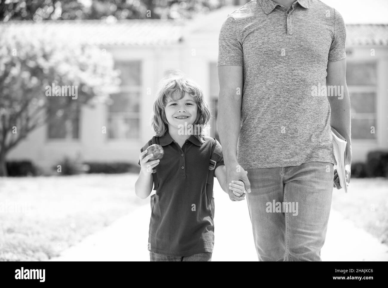 happy child with apple hold cropped fathers hand or teacher coming back from school, childhood Stock Photo
