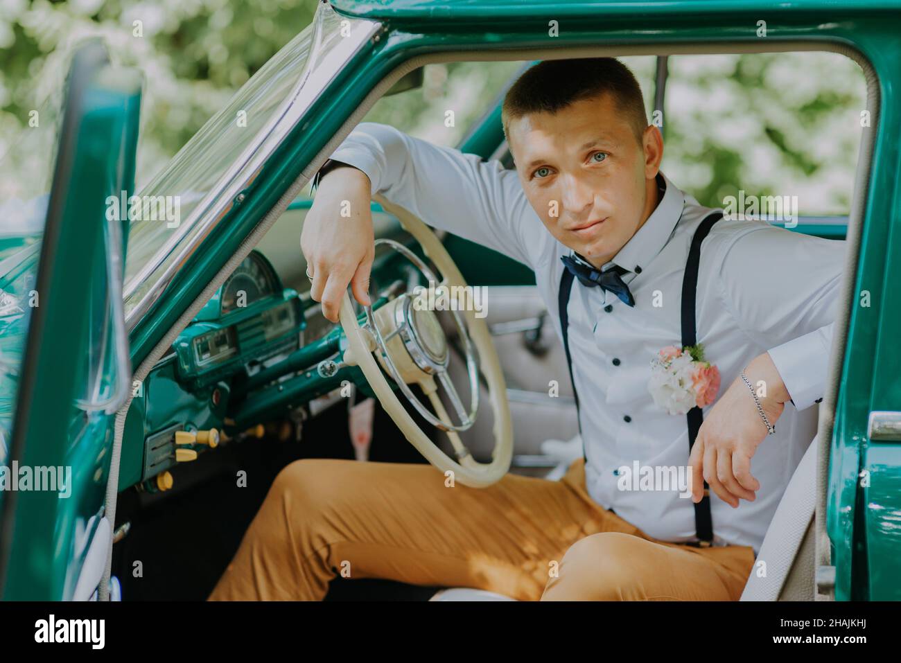 Retro-driver in the vintage car on the outdoor background. Handsome ...