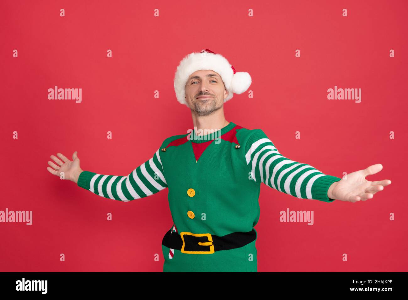 happy man in elf costume. xmas guy in santa claus hat on red background. happy new year. Stock Photo