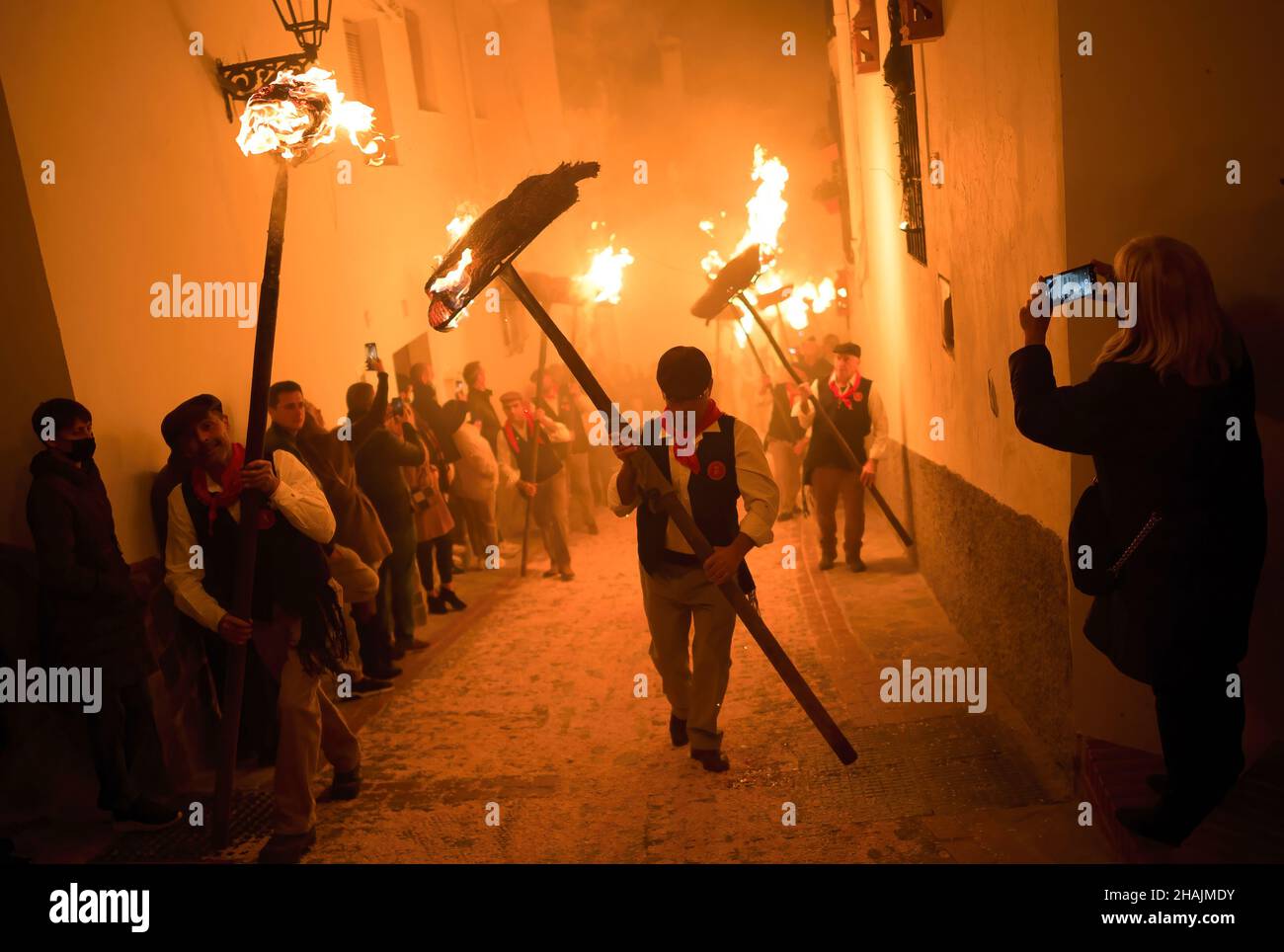 A villager is seen holding a torch as he takes part in the celebration of the 'Divina Pastora' Virgin procession. On the eve of the feast of St. Lucia in the small village of Casarabonela, every night of 12 December during Christmas season villagers take part in the ancient celebration of 'Los Rondeles' carrying burning wickers baskets (also known as 'rondeles') soaked in oil. Along the streets, the Virgin of 'Los Rondeles' is honoured by the devotees in a ritual of light and fire as thanksgiving for the harvest obtained. Stock Photo