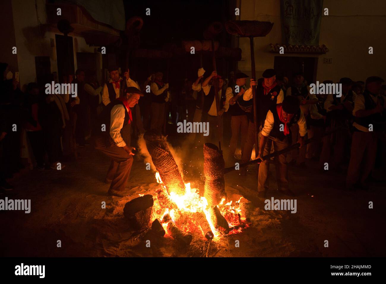 Villagers are seen lighting torches on a bonfire during the celebration