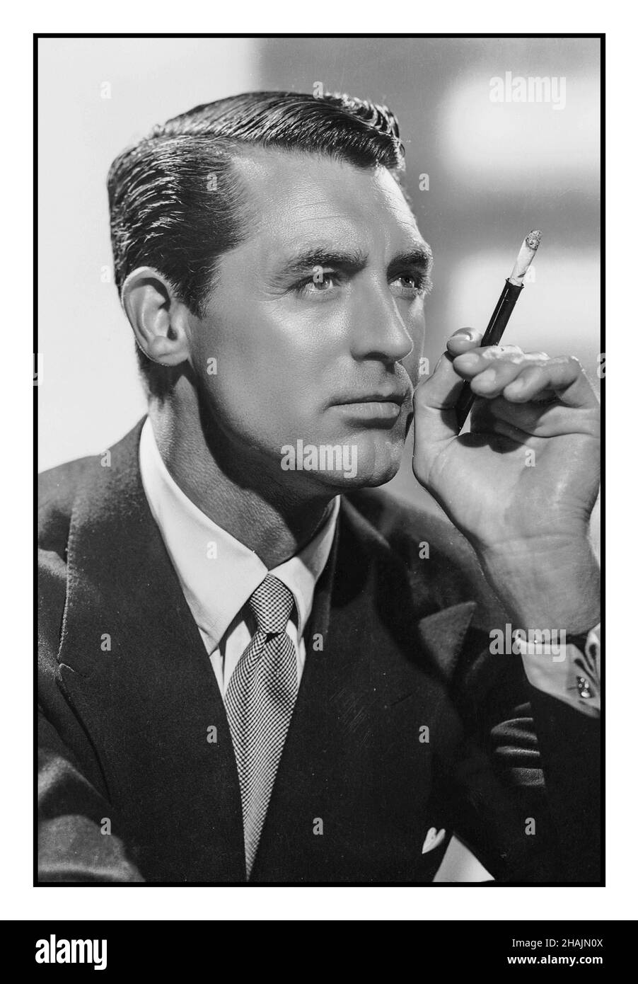CARY GRANT Vintage Hollywood B&W studio portrait 1931 Cary Grant with cigarette holder and cigarette CARY GRANT (1904-1986) English-born American Hollywood heart throb film star Stock Photo