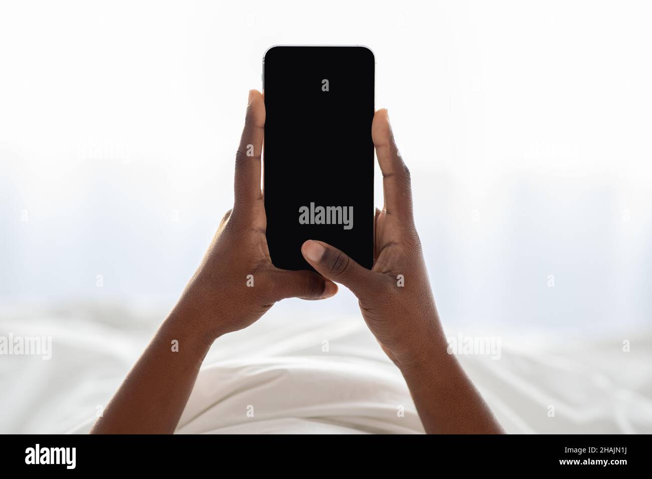 Female hands holding newest cellphone with empty screen Stock Photo