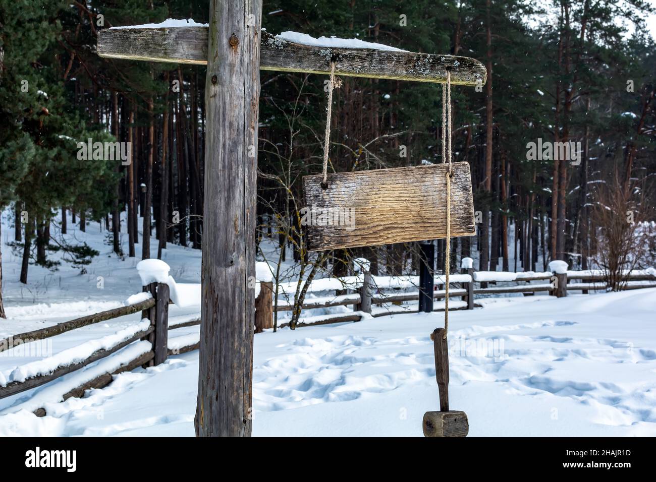 Wooden plate and a hammer used as a watchman rattle in old Latvian settlement yard. Stock Photo