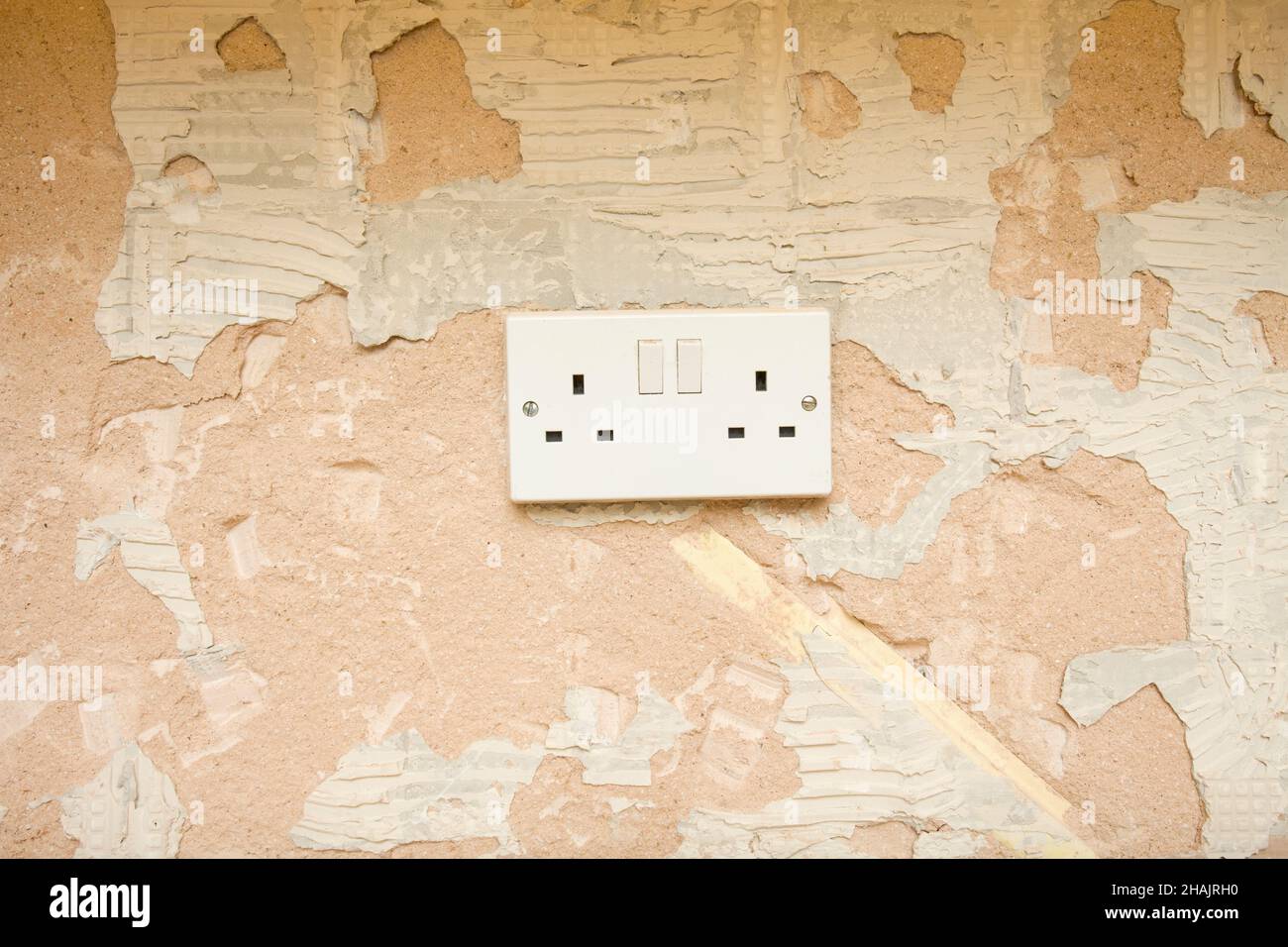 Double plug socket on old plastered wall. uk Stock Photo