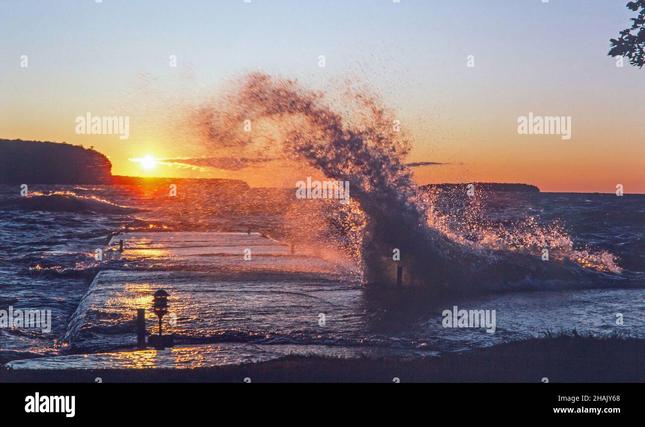 Angry Lake MIchigan waves crash against a pier at sunset at Ephraim, Wisconsin, on the Door County peninsula. Stock Photo