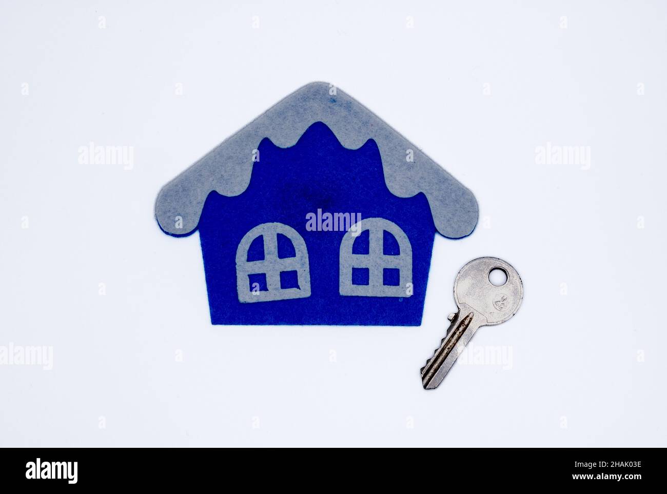 Handmade flat toy in form of house with white roof and windows on it and key Stock Photo
