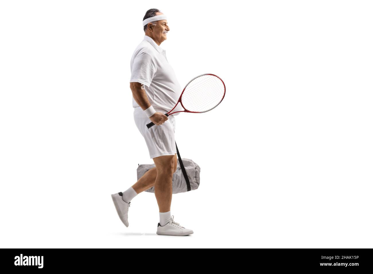 Full length profile shot of a mature male tennis player walking with a sports bag isolated on white background Stock Photo
