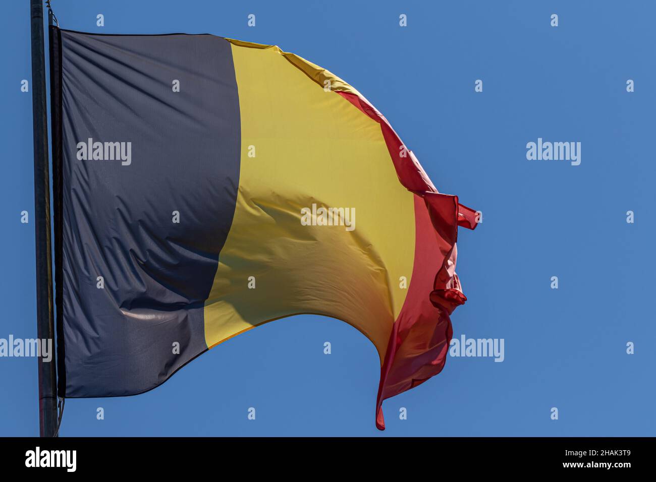 Belgian national flag waving on blue sky background. Kingdom of Belgium, BE Stock Photo