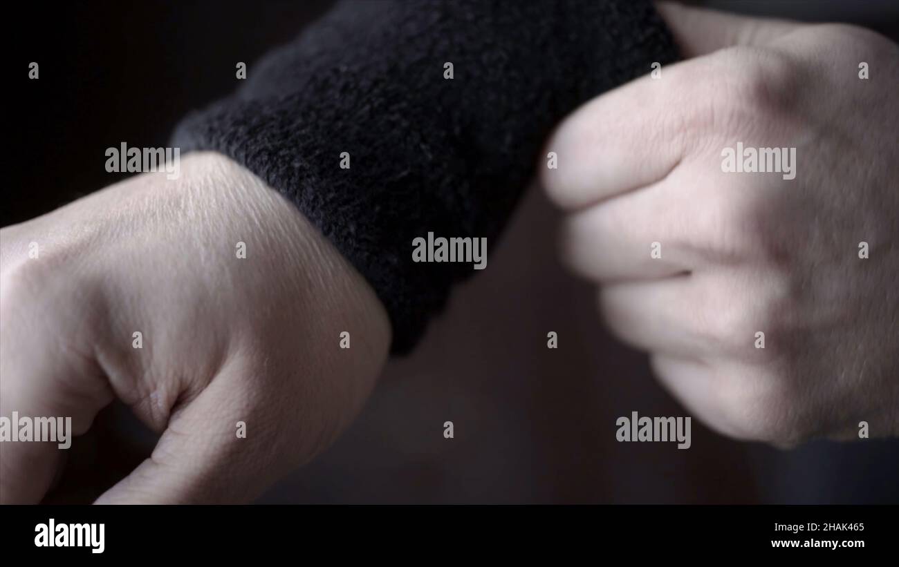 Athlete wears black wristbands. Action. Closeup of athlete adjusts his