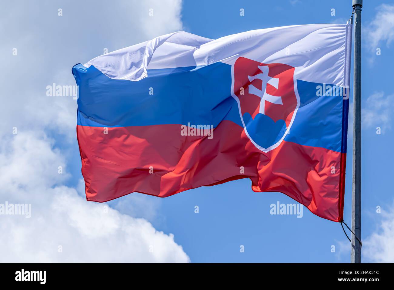 Slovak national flag waving on blue sky background. Slovak Republic, SK Stock Photo