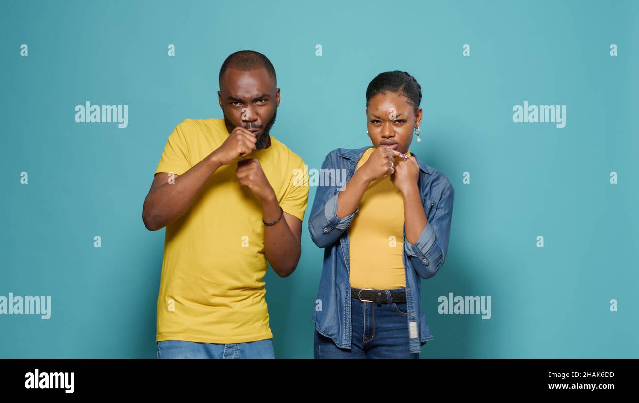 African american couple punching air with fists in front of camera. Man