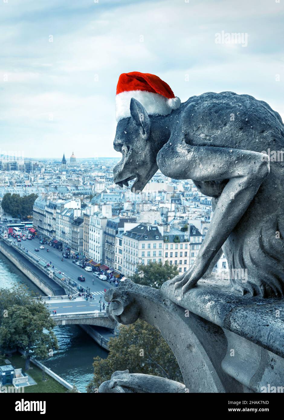 Christmas, New Year and fun concept, gargoyle (chimera) of Notre Dame de Paris cathedral with Santa hat, Paris, France. This place is landmark of Pari Stock Photo