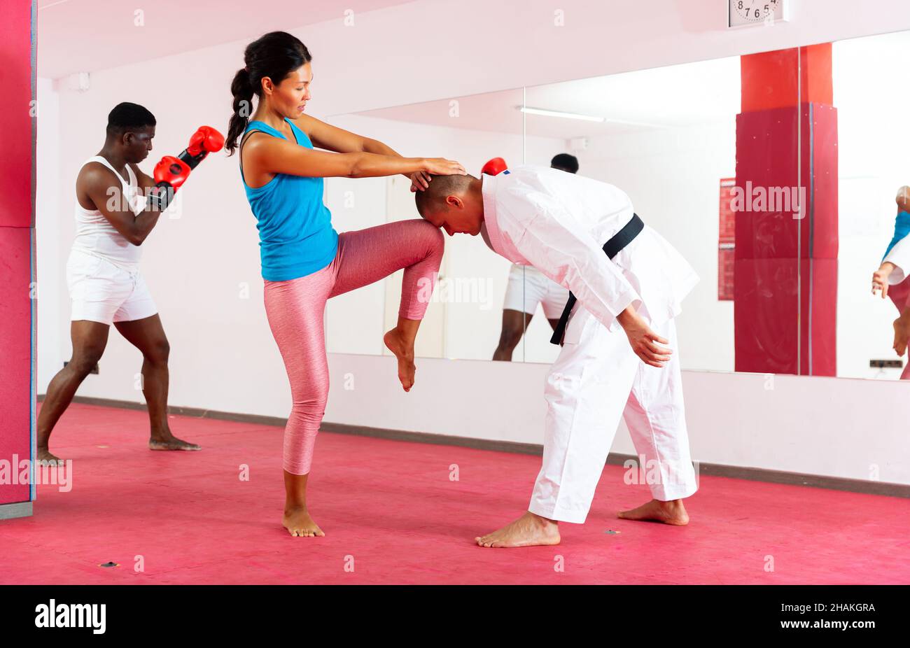 Oriental woman training selfdefence moves with her trainer. African