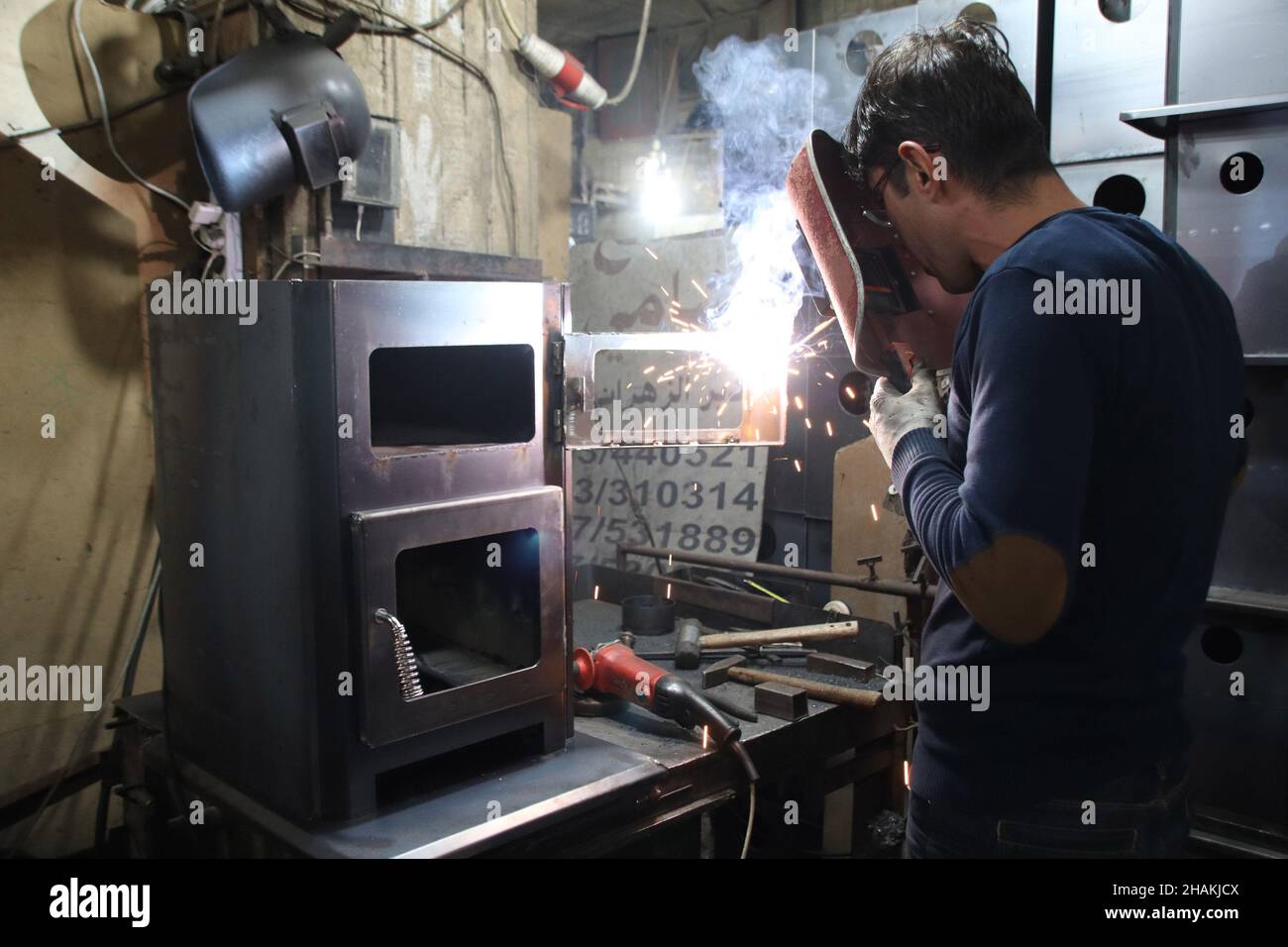 Beirut, Lebanon. 10th Dec, 2021. A worker operates on woodand diesel