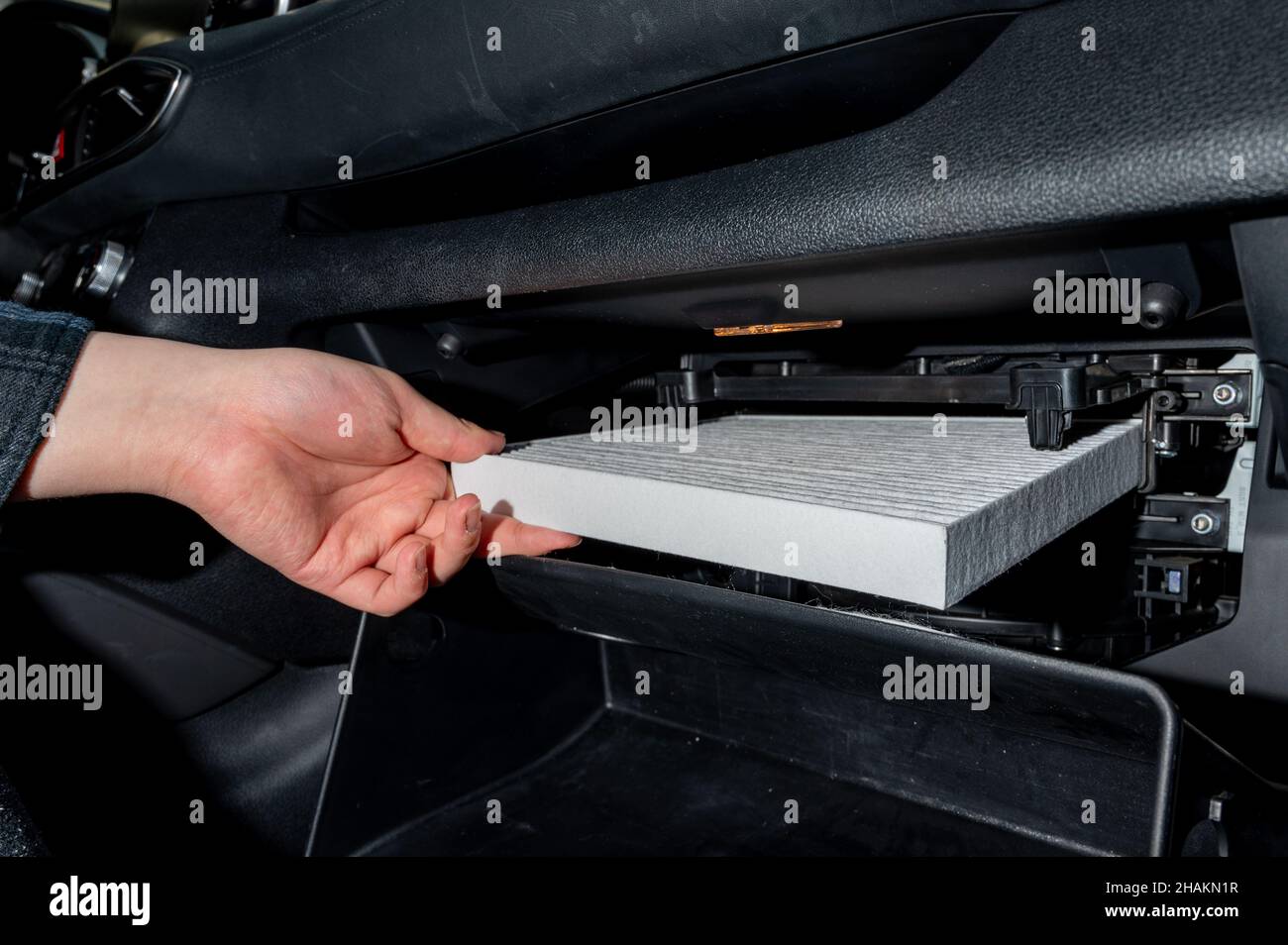 Changing the air filter inside the car. car maintenance. Stock Photo