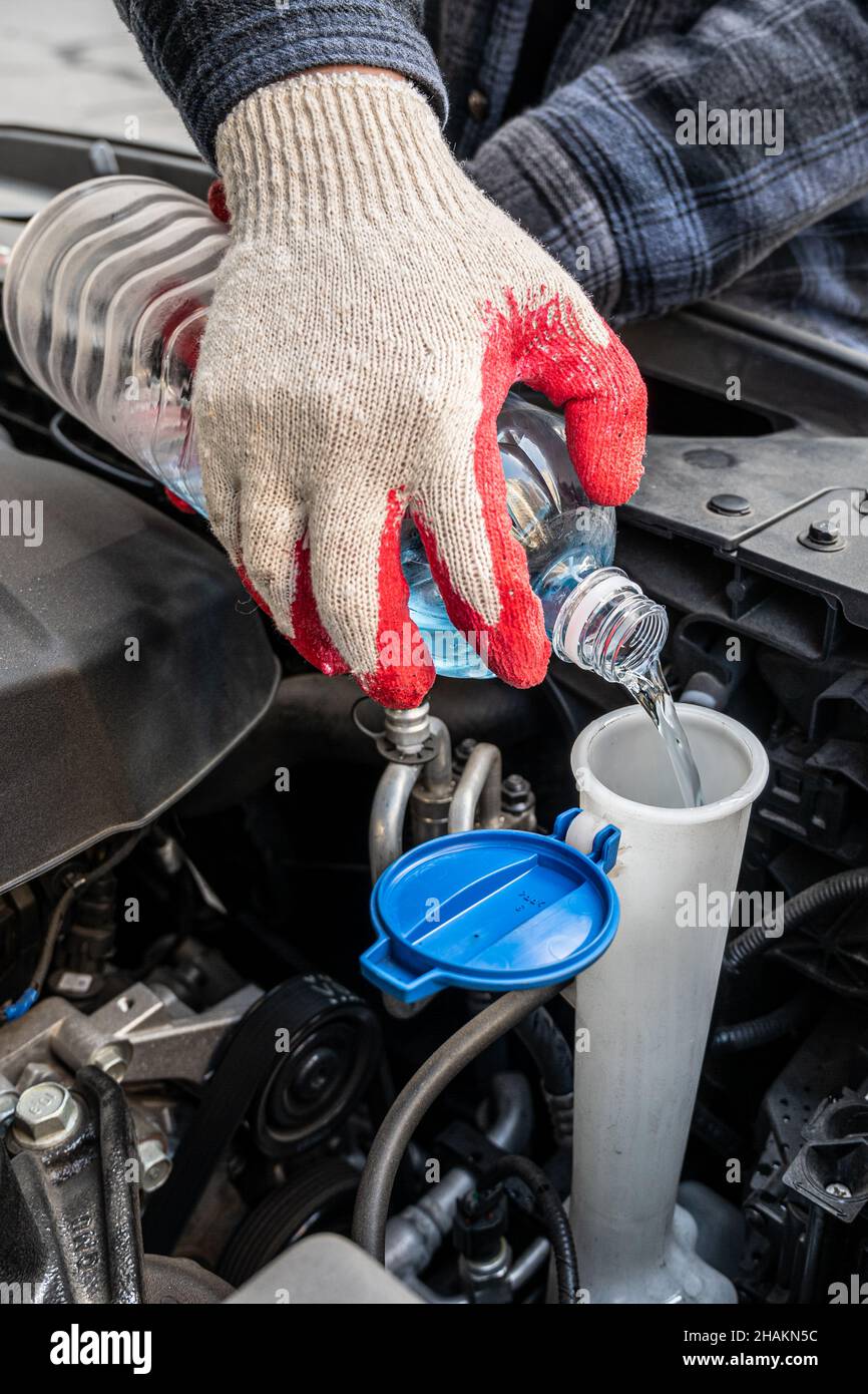 Automobile Maintenance. Filling the Windshield Washer Fluid on a Car. Stock Photo