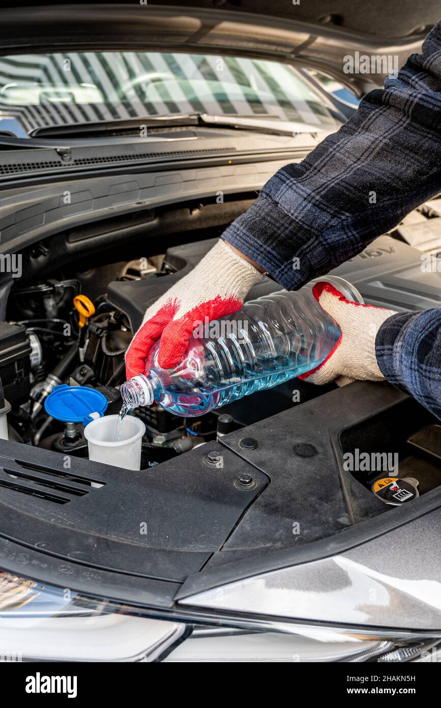 Automobile Maintenance. Filling the Windshield Washer Fluid on a Car. Stock Photo