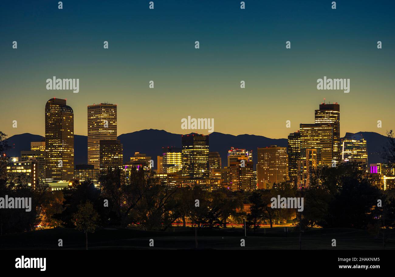 Illuminated Denver Downtown Towers and Front Range Mountains in a Background. Denver Colorado Skyline at Dusk Stock Photo