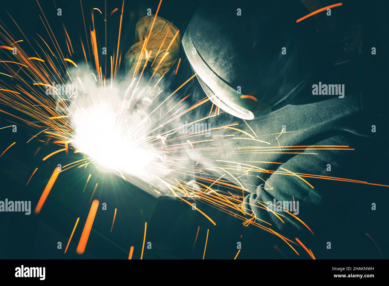 Professional Welder is Welding Two Metal Parts Together. Sparks Flying All Around. Metal Industry Theme. Stock Photo