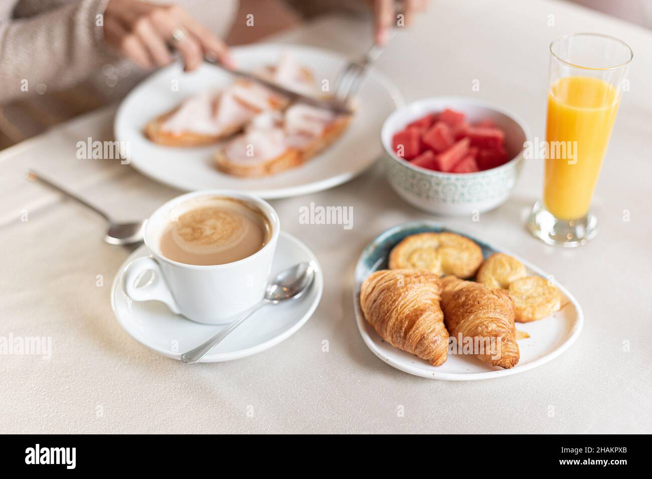 Coffee and croissant for breakfast served at a table. Stock Photo