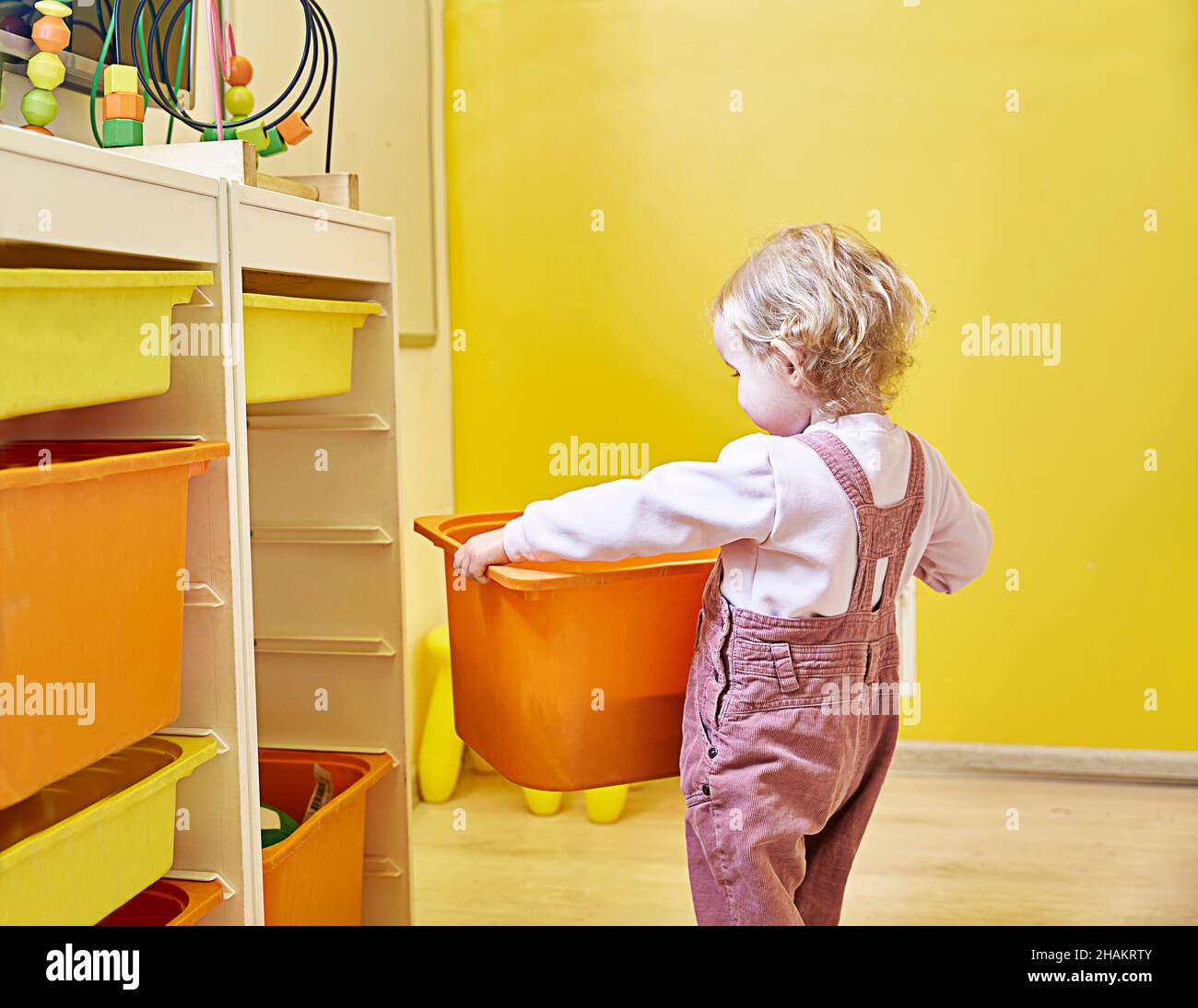 child uses a rack with drawers of the chest of drawers type, which allows effective use of small living spaces. Copy space. Stock Photo