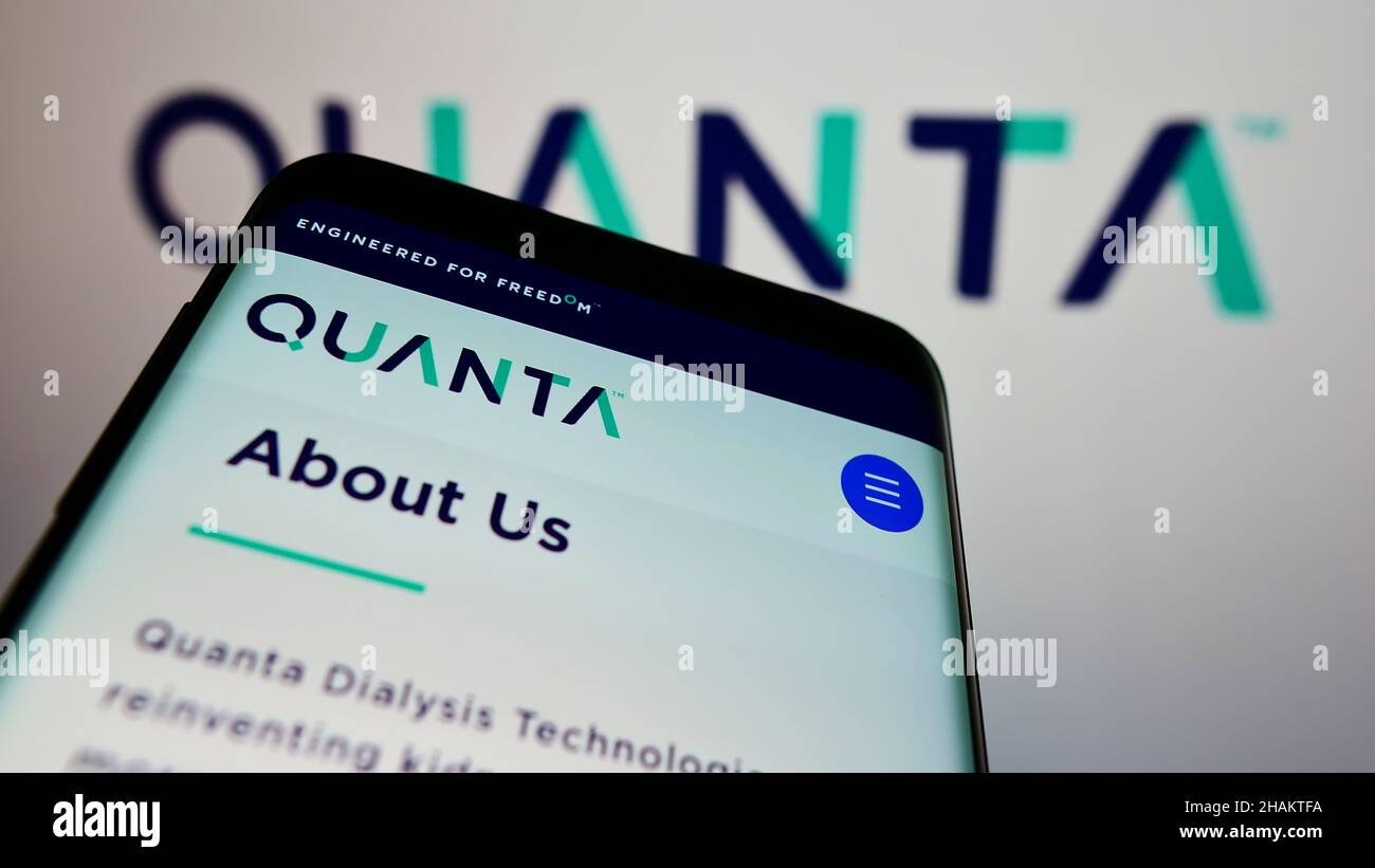 Mobile phone with webpage of British company Quanta Dialysis Technologies Limited on screen in front of logo. Focus on top-left of phone display. Stock Photo