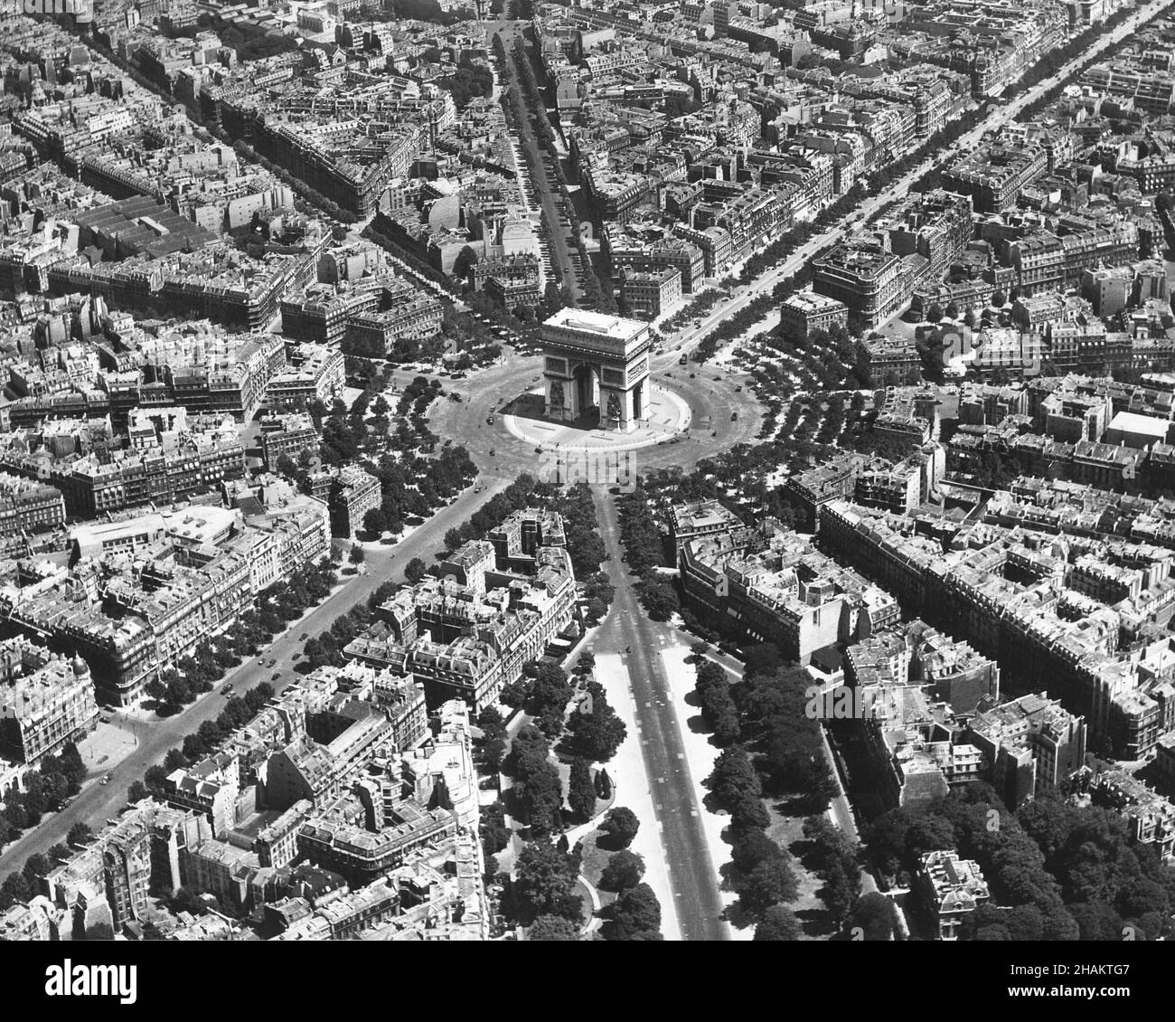 Paris - low level aerial photo centered on the Arc de Triomphe during Occupation, 1944. The view of the streets of Paris as they radiate out from the Arc de Triomphe was taken from a low flying US airplane using a photo method called low-level-oblique. The camera position is roughly west of the Arc de Triomphe and the street that points most to photographer is Avenue Foch. Avenue des Champs-Elysees runs from the center to the upper right corner of the image. There are less than thirty motor vehicles on the circular Place de l'Etoile around the famous Arch. Stock Photo