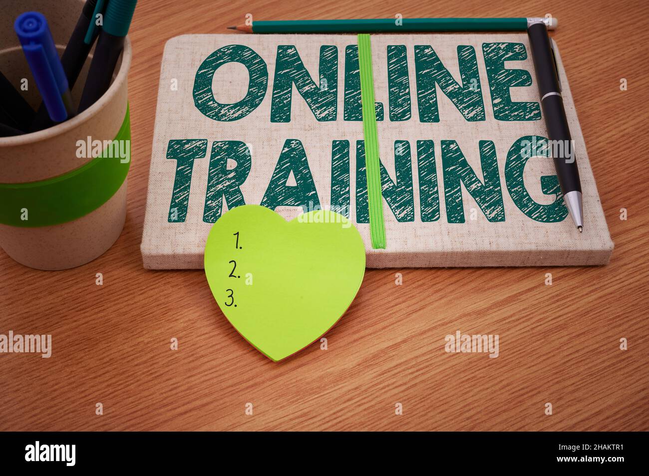 Conceptual caption Online Training. Word for Take the education program from the electronic means Plain Blank Open Notebooks With Stack Of Pens Stock Photo