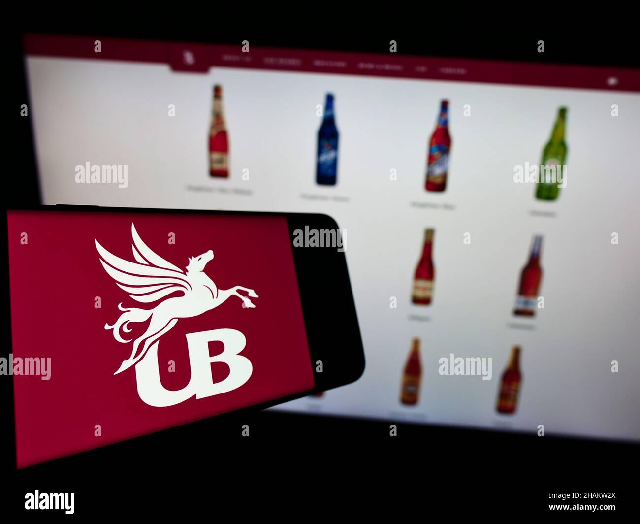 Cellphone with logo of company United Breweries Holdings Limited (UBHL) on screen in front of website. Focus on center-left of phone display. Stock Photo