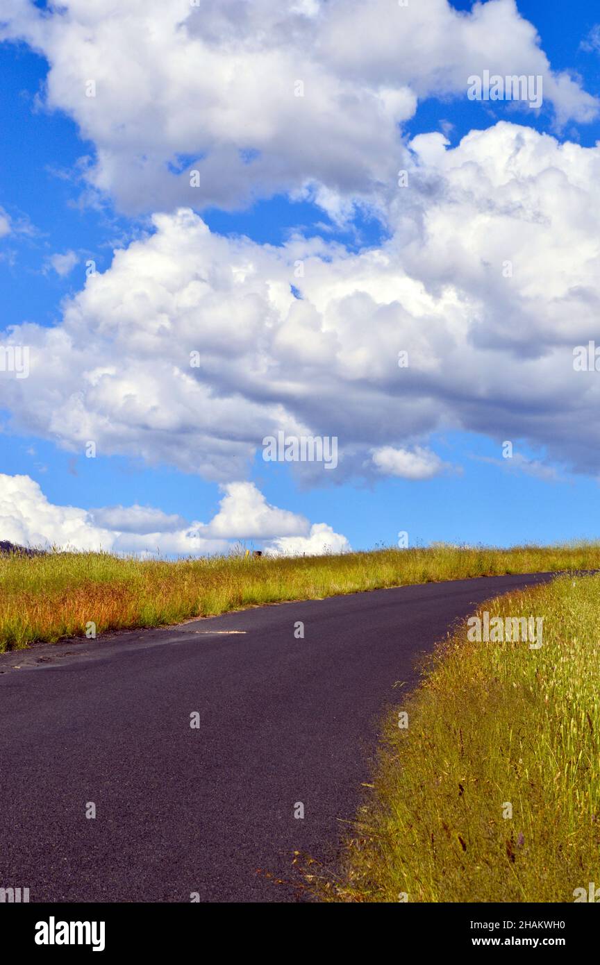 A road with a cloudy blue sky Stock Photo - Alamy