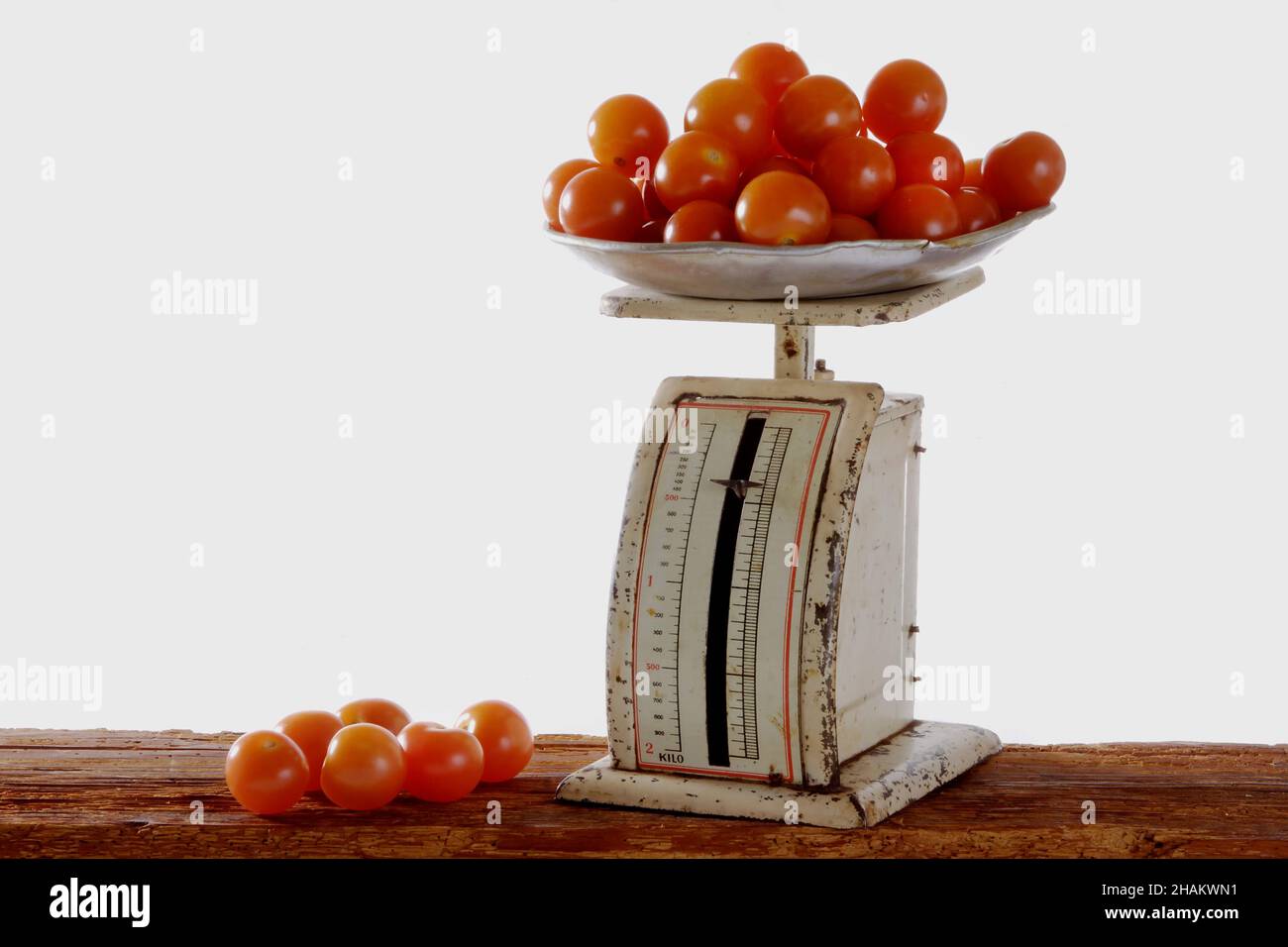 tomatoes on old metal scales on wooden beams, isolated Stock Photo