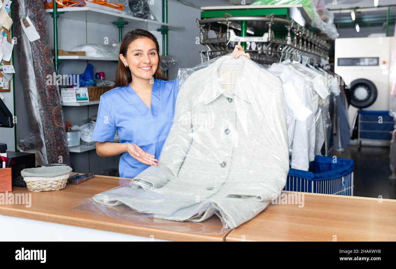 Portrait of efficient friendly female laundry worker at workplace Stock
