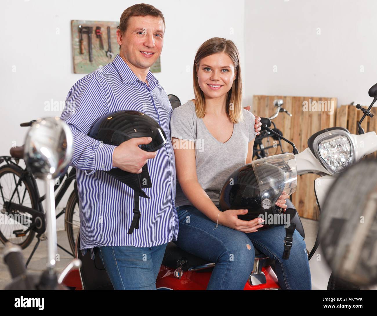 man and woman with helmets in hands Stock Photo - Alamy