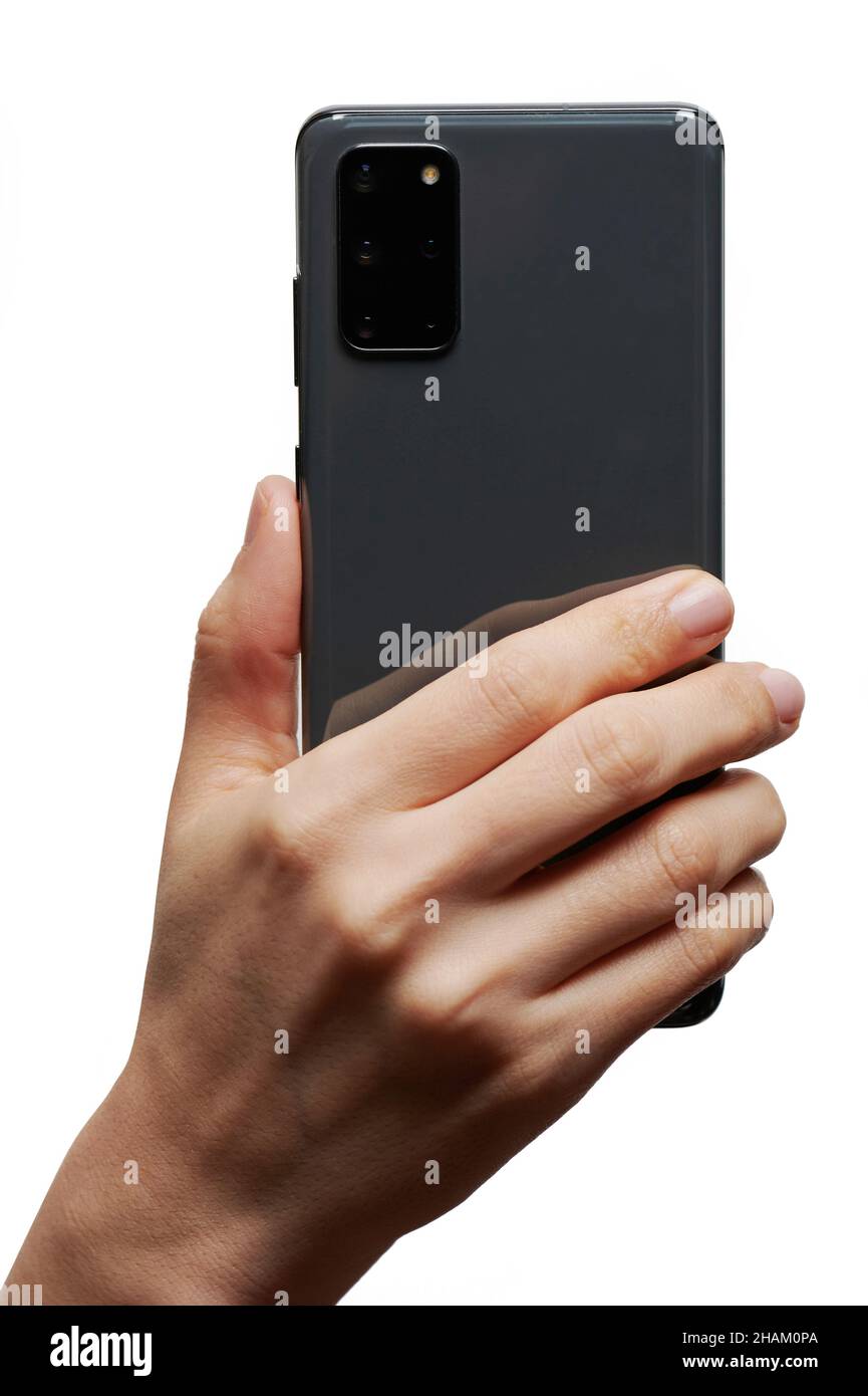 Smartphone in hand back view with camera isolated on studio background Stock Photo