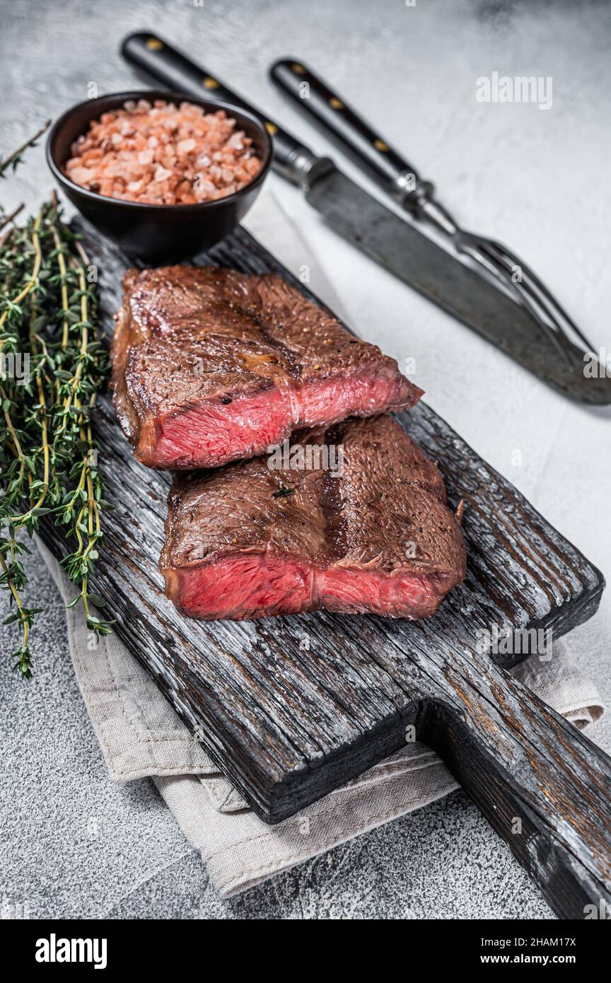 Roasted Shoulder Top Blade or flat iron beef meat steaks on wooden board. White background. Top