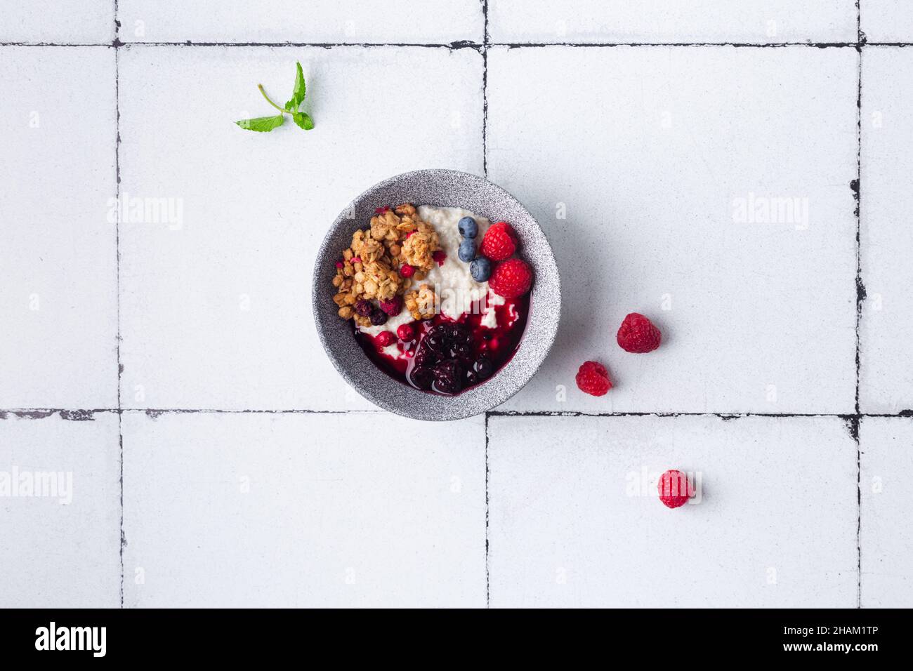 Healthy breakfast cereal porridge with berries and jam in bowl. Closeup view. Stock Photo