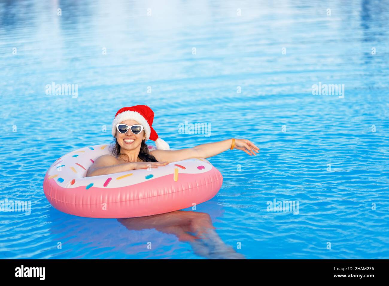 Happy man in sun hat and sunglasses on side of swimming pool on summer  vacation Stock Photo