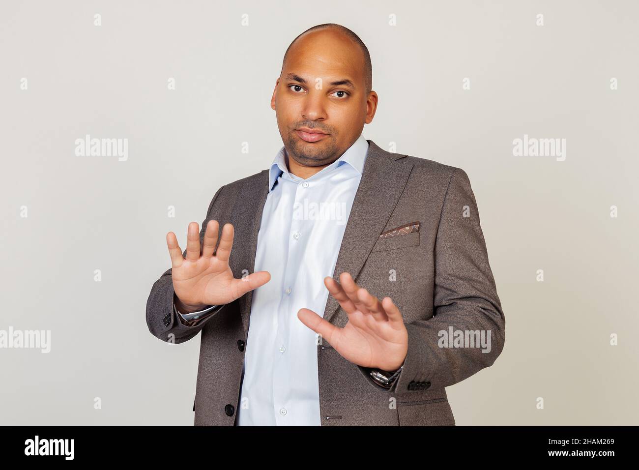 Portrait of shocked young African American businessman guy, scared and frightened by fear expression, stopped hand gesture, shouting in shock. Panic Stock Photo