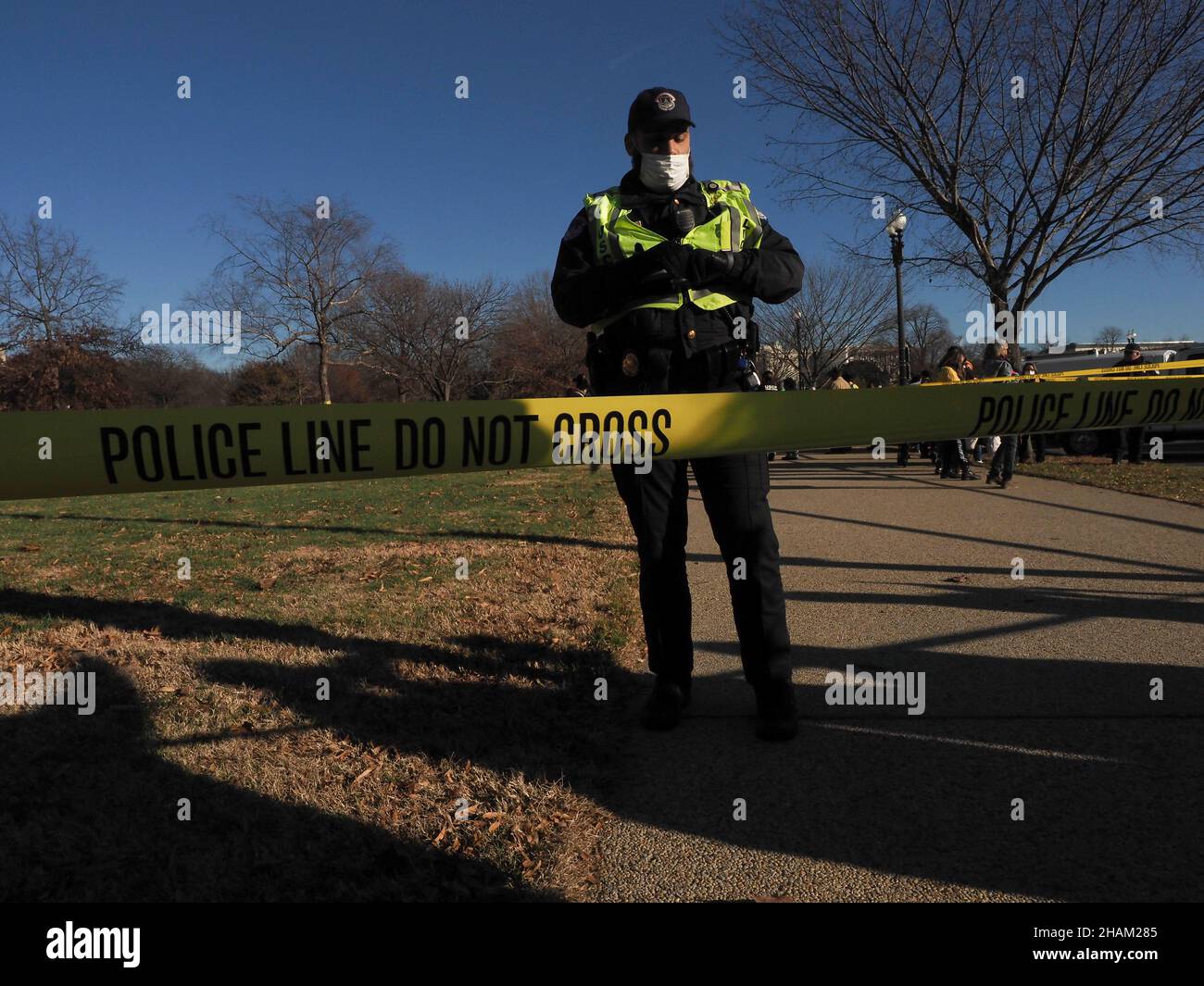 December 13, 2021, Washington, District of Columbia, USA: A US Capitol Police officer stands behind the police tape separating those who committed civill disobedience during The Poor PeopleÃs Campaign 'Getting it Done in 2021' rally and those lining the sidewalks in support.:A demonstration that drew participants from 33 states held at the US Capitol demanded Congress pass voting rights protections and the Build Back Better plan before the end of 2021. (Credit Image: © Sue Dorfman/ZUMA Press Wire) Stock Photo