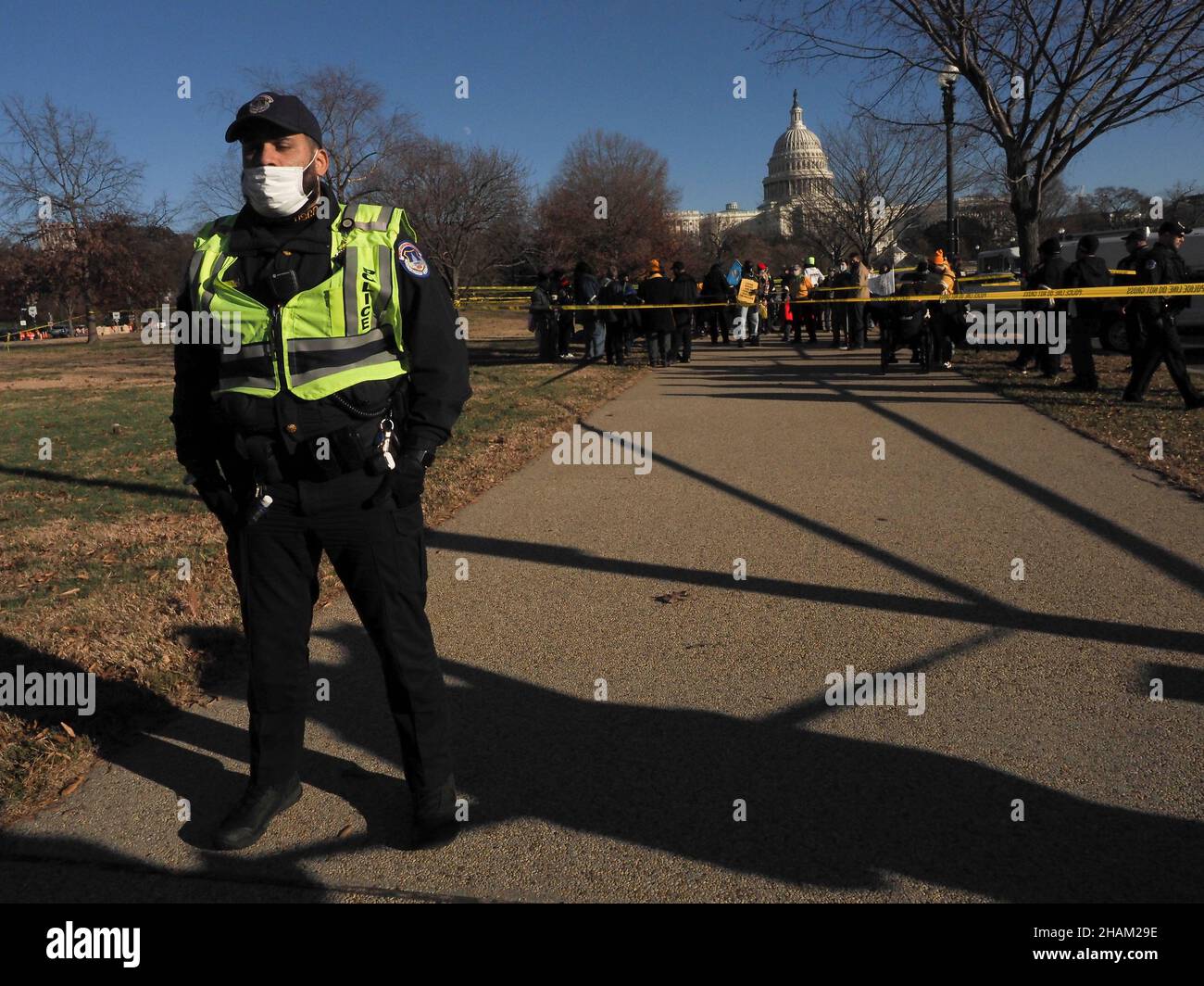December 13, 2021, Washington, District of Columbia, USA: A US Capitol Police officer stands in front of police tape separating those who committed civill disobedience during The Poor PeopleÃs Campaign 'Getting it Done in 2021' rally and those lining the sidewalks in support.:A demonstration that drew participants from 33 states held at the US Capitol demanded Congress pass voting rights protections and the Build Back Better plan before the end of 2021. (Credit Image: © Sue Dorfman/ZUMA Press Wire) Stock Photo