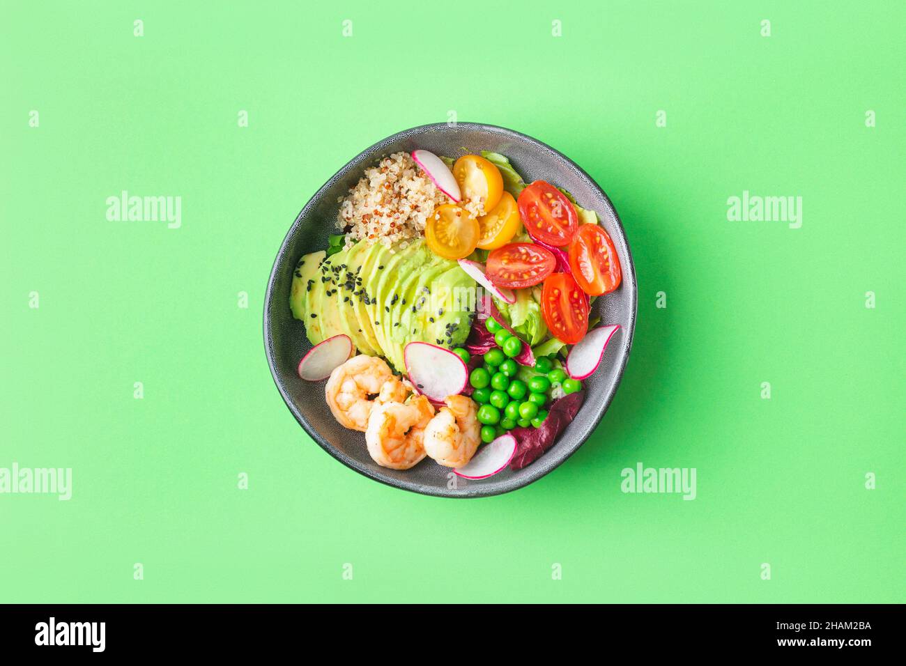 Fresh Avocado, shrimps salad with green pies, cherry tomatoes, herbs and olive oil, lemon dressing. healthy food Stock Photo